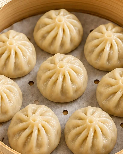 Freshly steamed momos in a bamboo steamer